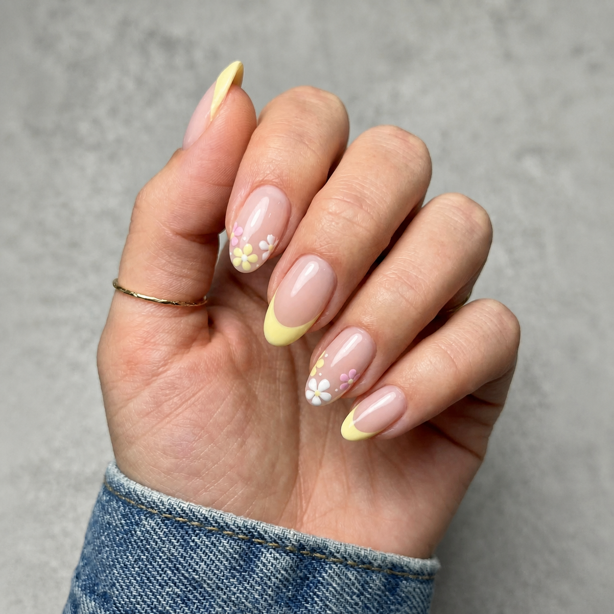 Soft pink manicure with yellow French tips and flowers