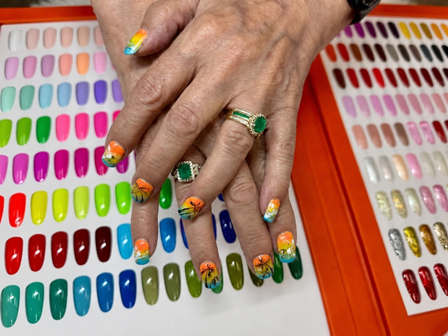 Bright custom nail art shown over the salon color collection